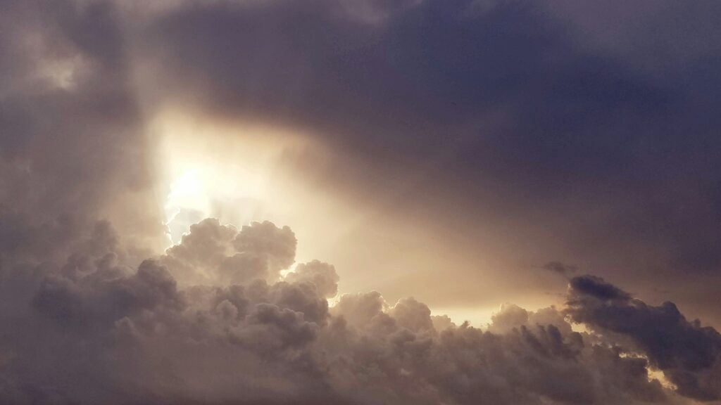 Sunlight breaking through dark clouds, symbolizing how to use AI without fear or confusion.