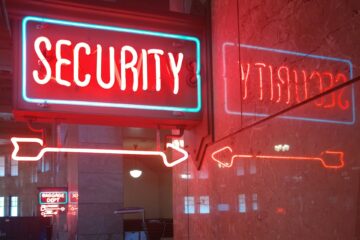Neon “SECURITY” sign with arrows, symbolizing defense against phishing and other online pests.